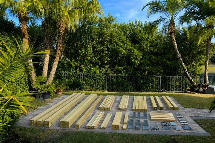 Pergola materials staged on a paver patio before construction
