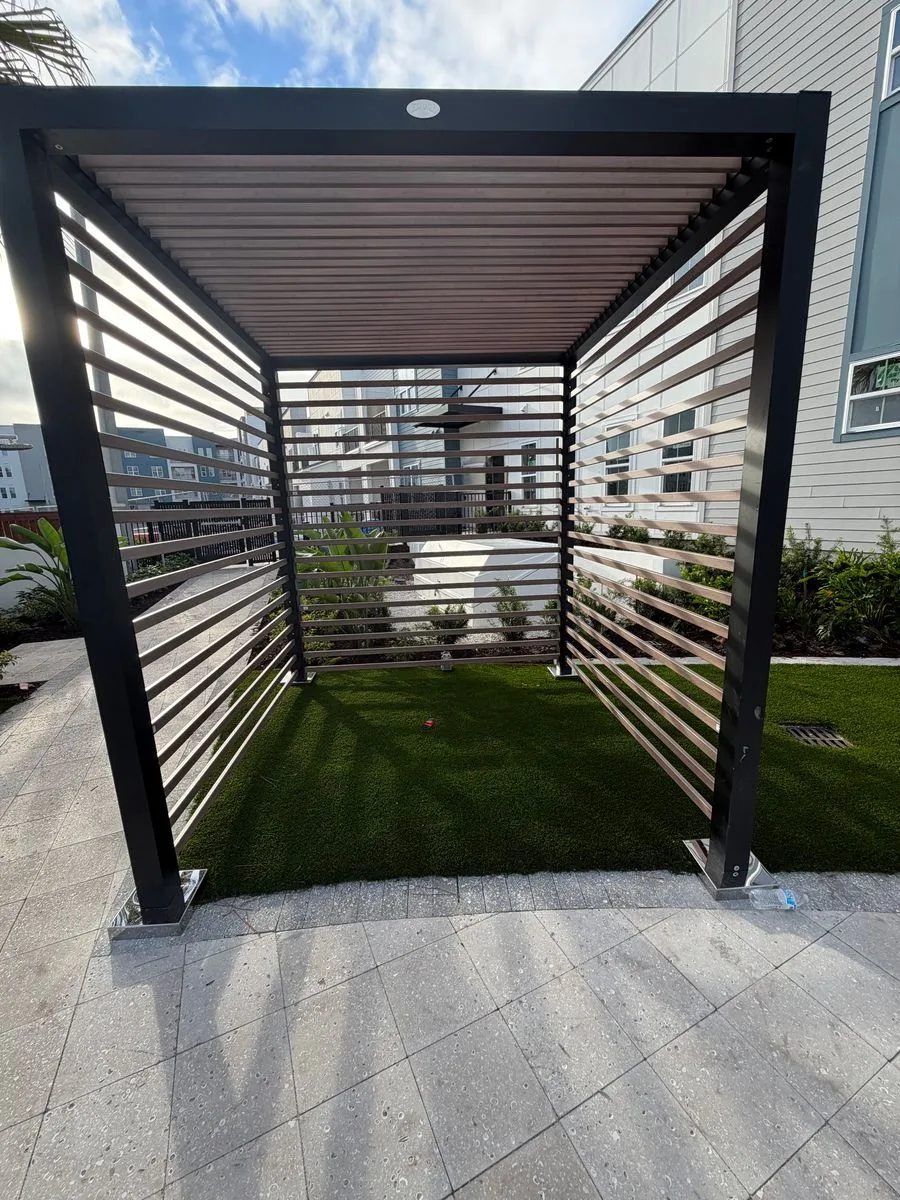 Modern black aluminum slat pergola installed over artificial turf in Jacksonville, FL